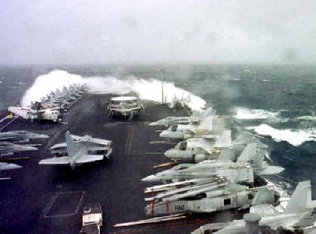 Military aircraft on aircraft carrier in big waves