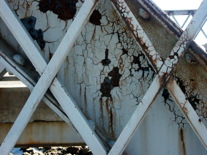 Blistering and peeling of protective coating subjected to regular deicing salt application.