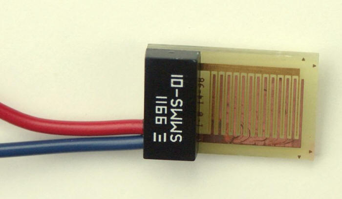 Interlocking combs of gold and copper electrodes in a Sereda humidity sensor.