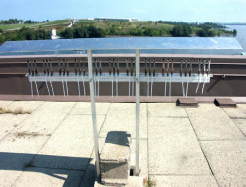 Atmospheric corrosion test rack for the evaluation of corrosion prevention compounds with a view of historical Fort Henry in the background